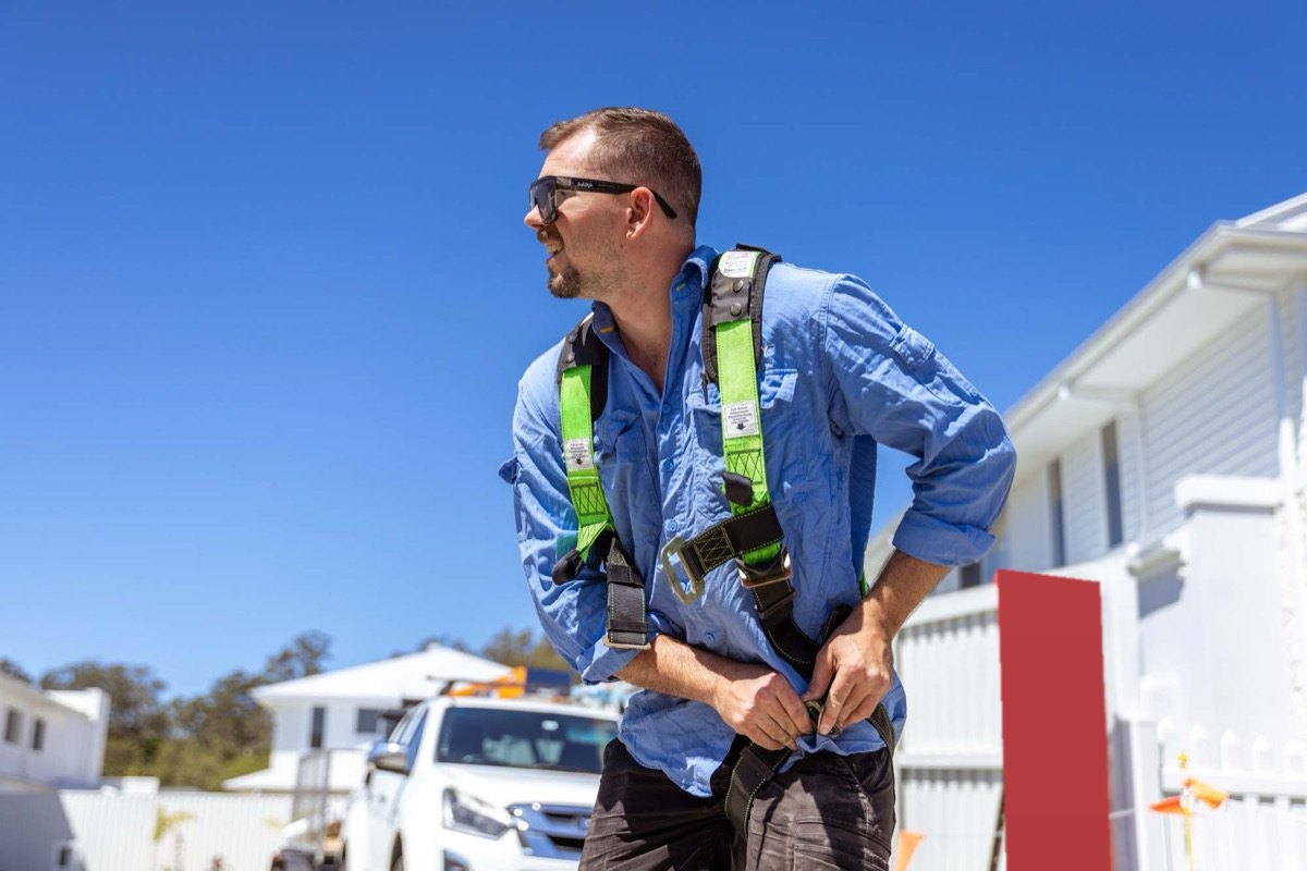 A builder in a safety harness on a residential site