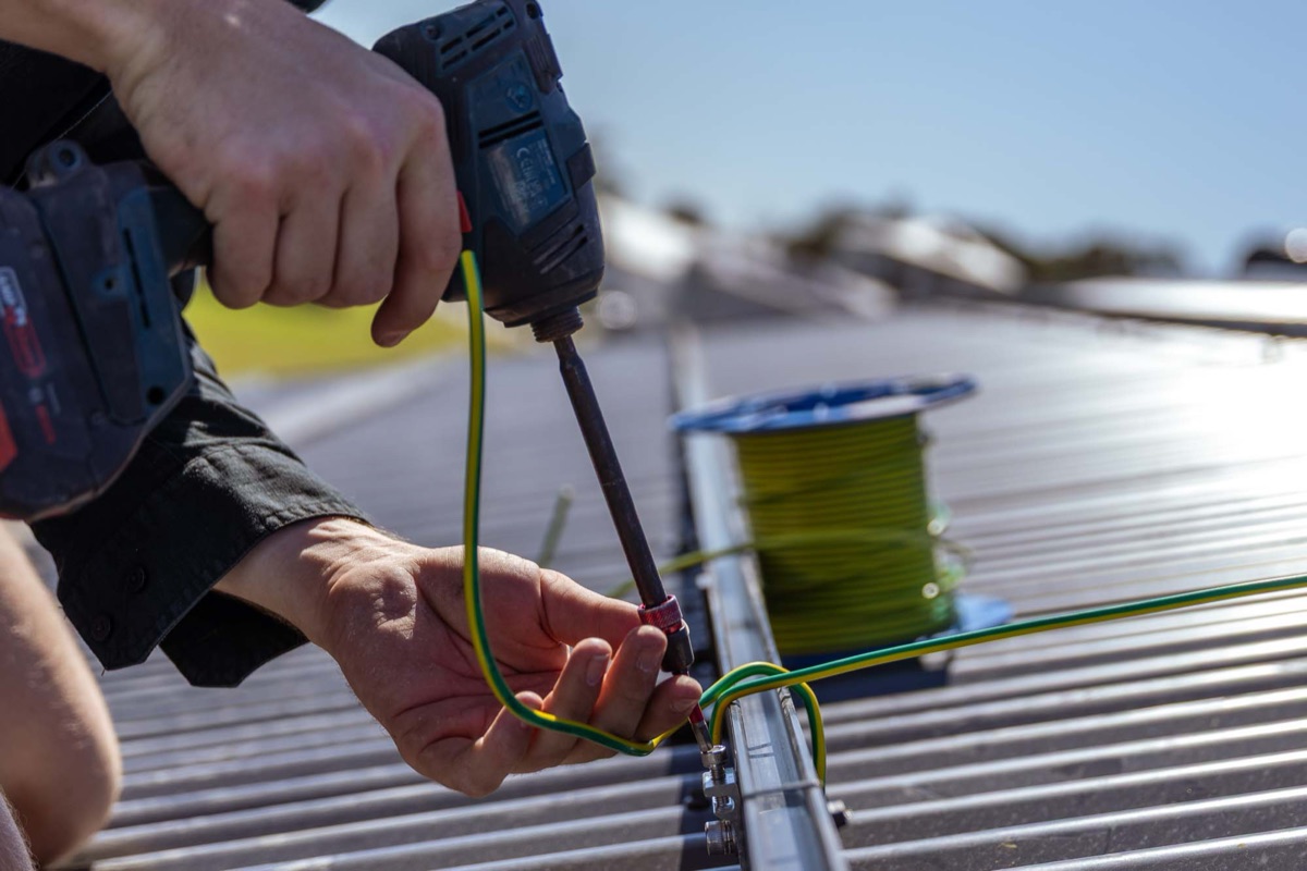 A roofer fixing sheeting on a metal roof