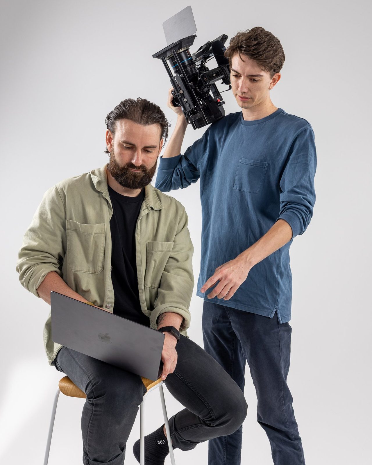 Adrian Fowler checking work on a laptop while Lochie Burgdorf looks on