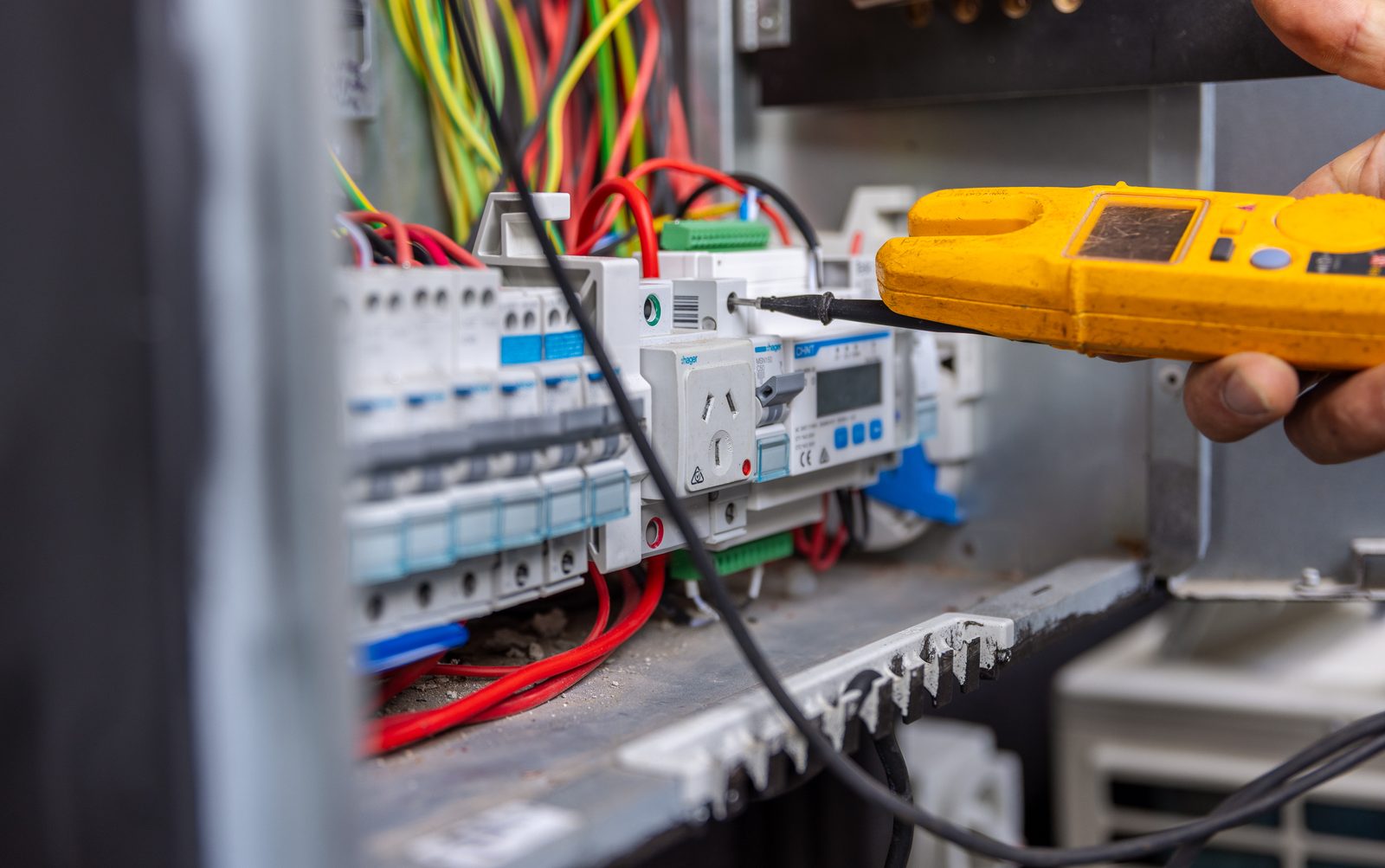 An electrician testing a switchboard